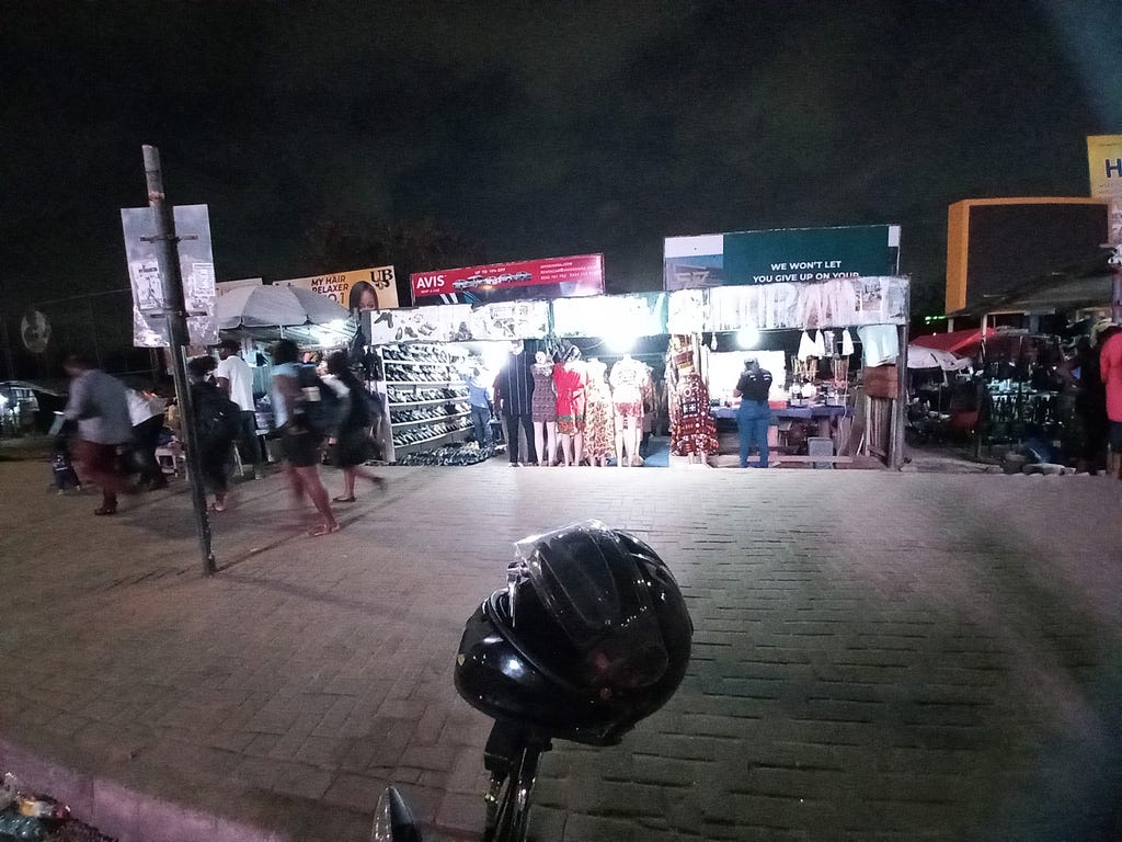 Three consecutive stalls at Spanner Junction market lit up at night by Kofa’s battery power
