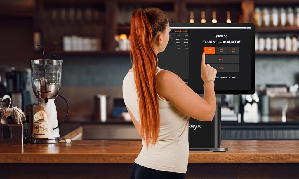 A woman using the Pays POS system at a cafe counter to add a tip, showcasing the user-friendly interface for streamlined transactions.