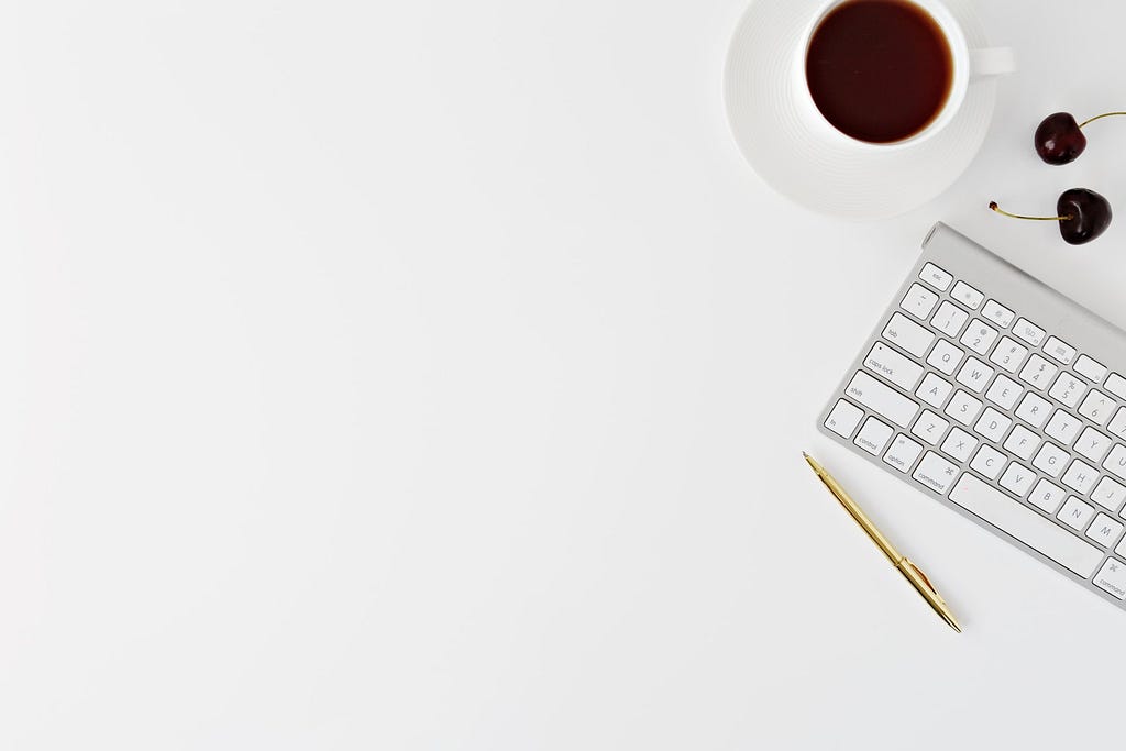 Minimalist keyboard and coffee cup — representing minimalist research