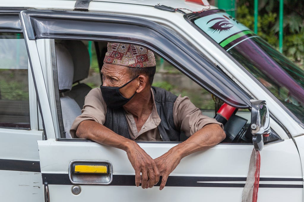 Taxi driver waiting for a fare wearing a face mask in Kathmandu, Nepal. Photo: © Mark Benham/Shutterstock