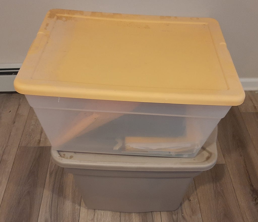 Plastic storage bins filled with old papers no longer needed