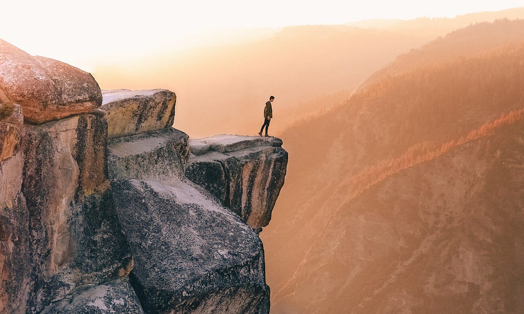 Person standing on edge of a cliff