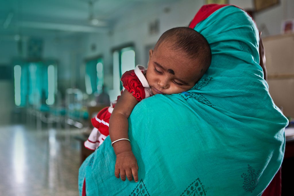 A mother brings her malnourished baby to the Child In Need Institute emergency ward in Kolkata, India, June 4, 2009. Photo by Andrew Aitchison/Alamy