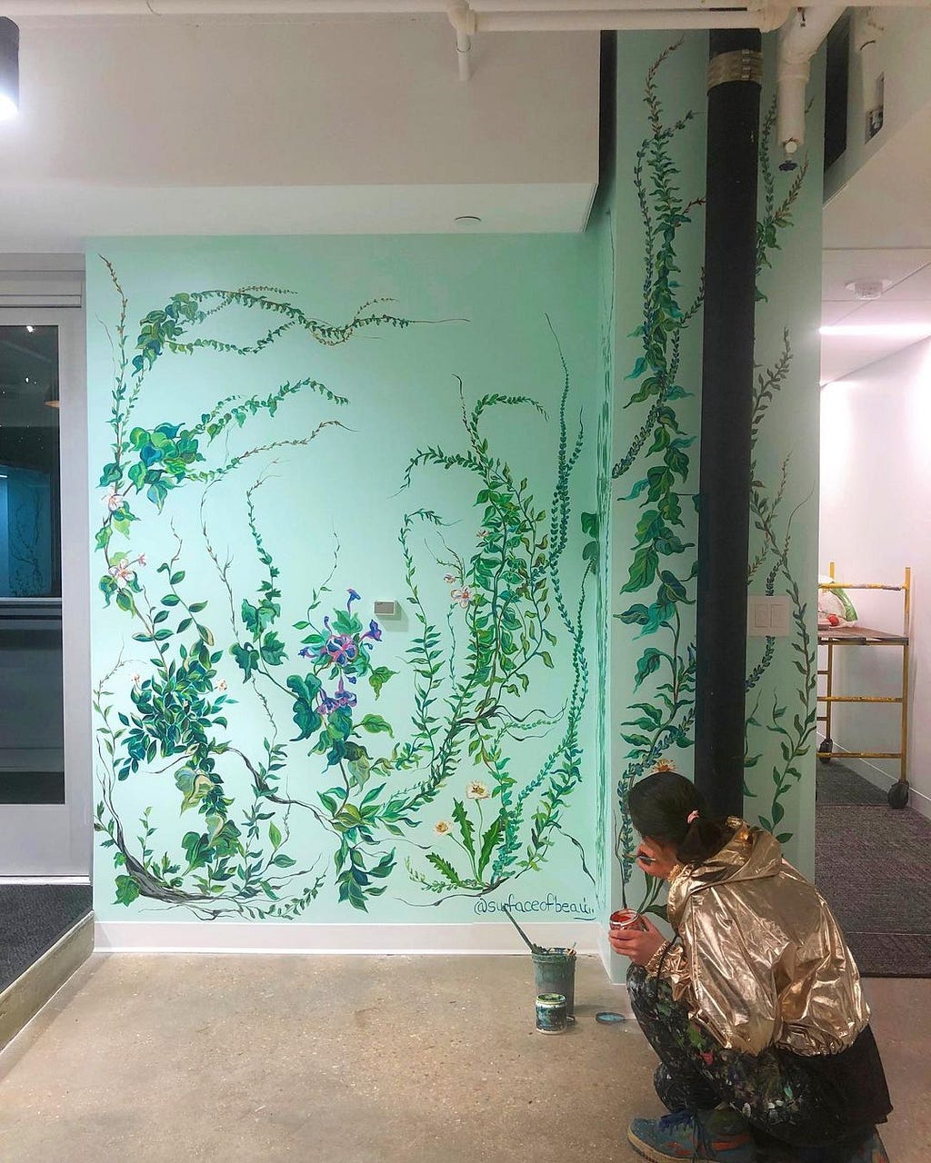 Natasha May Platt painting a floral mural