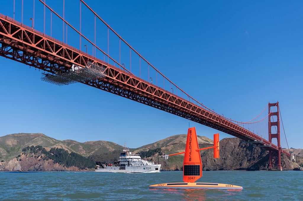 Saildrone USV and NOAA RV Reuben Lasker under the Golden Gate Bridge