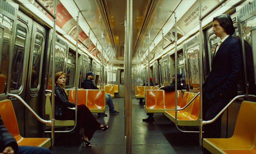 Adam Driver and Scarlett Johannessen ride the subway apart from each other.