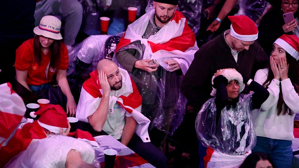 photo of sad England fans, some of whom are wearing Christmas hats