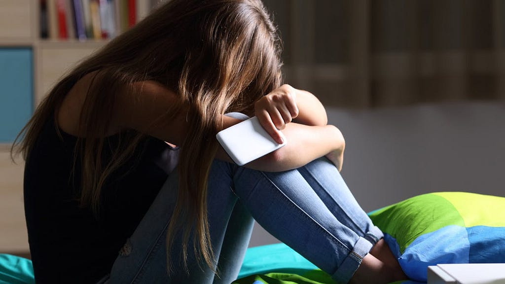 A Teenage girl, depressed or sad due to negative effect social media.