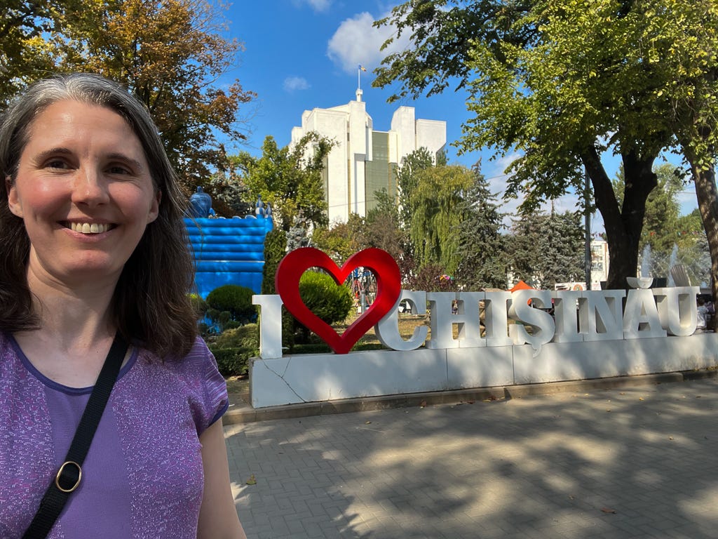 Author standing in front of a sign that reads “I love Chisinau.”
