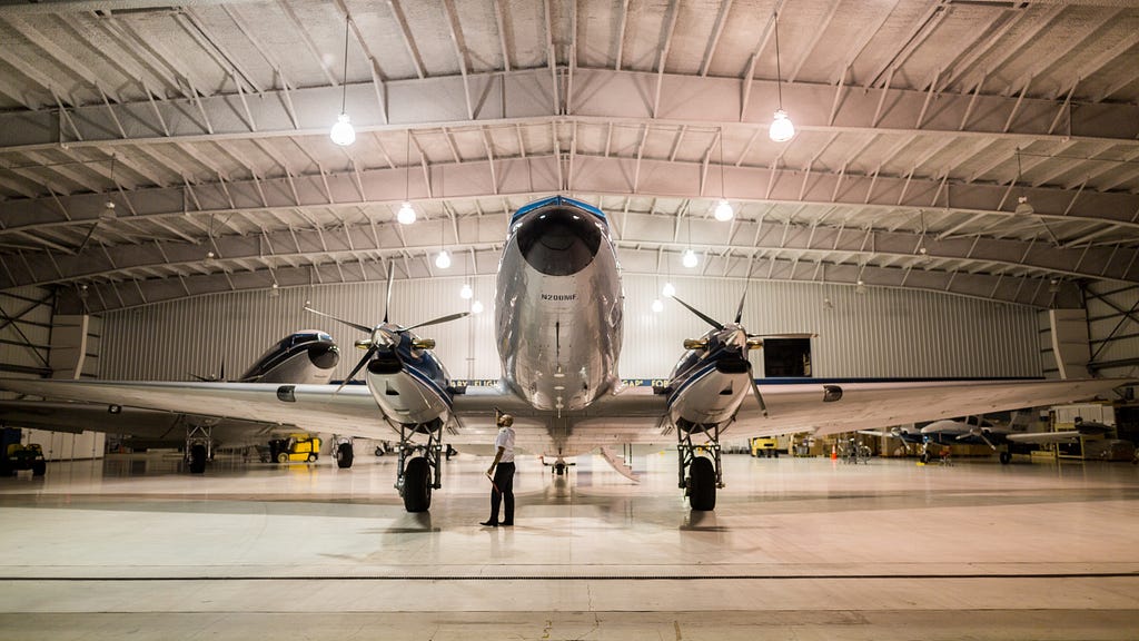 An aircraft Engineer inspecting an aircraft in the hangar