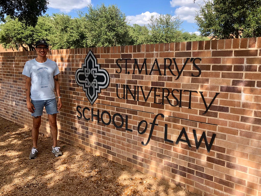 Edgar stands in front of the law school, proud of his accomplishment of getting in and starting his first year.