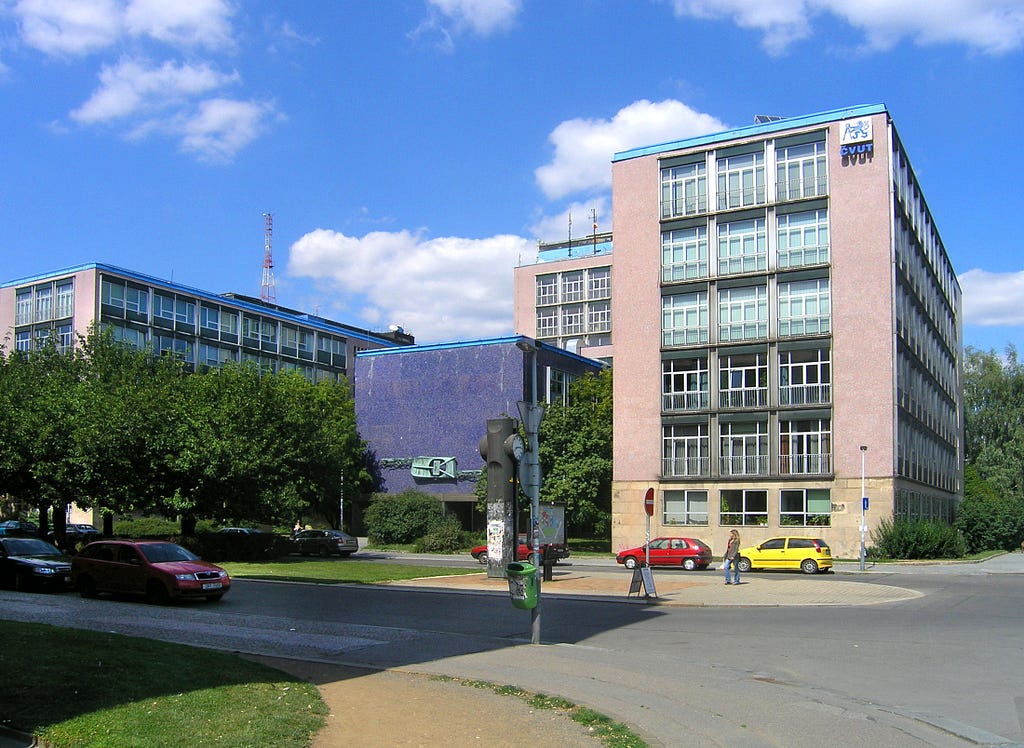 4 blocky buildings of varying height, up to about 6 floors, as seen from across the street.