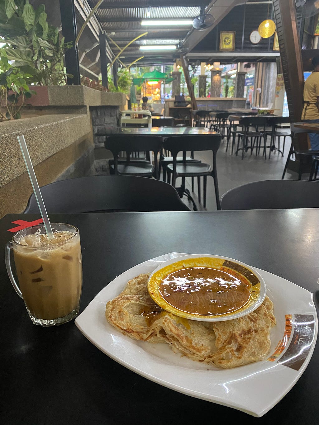 Roti canai and iced coffee in a mamak