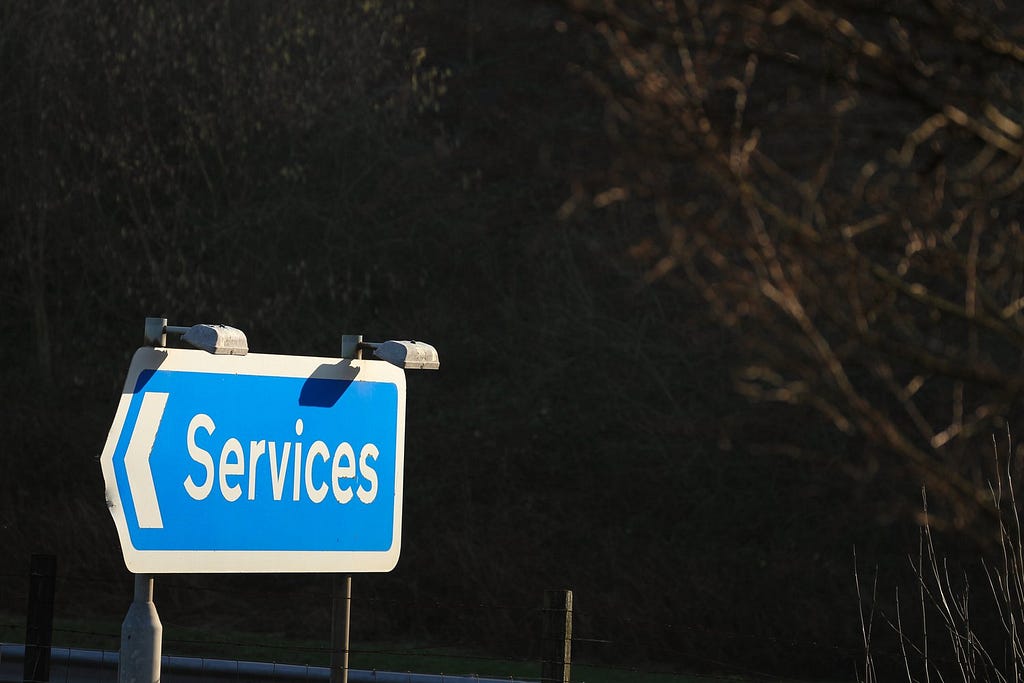 A blue road sign saying services