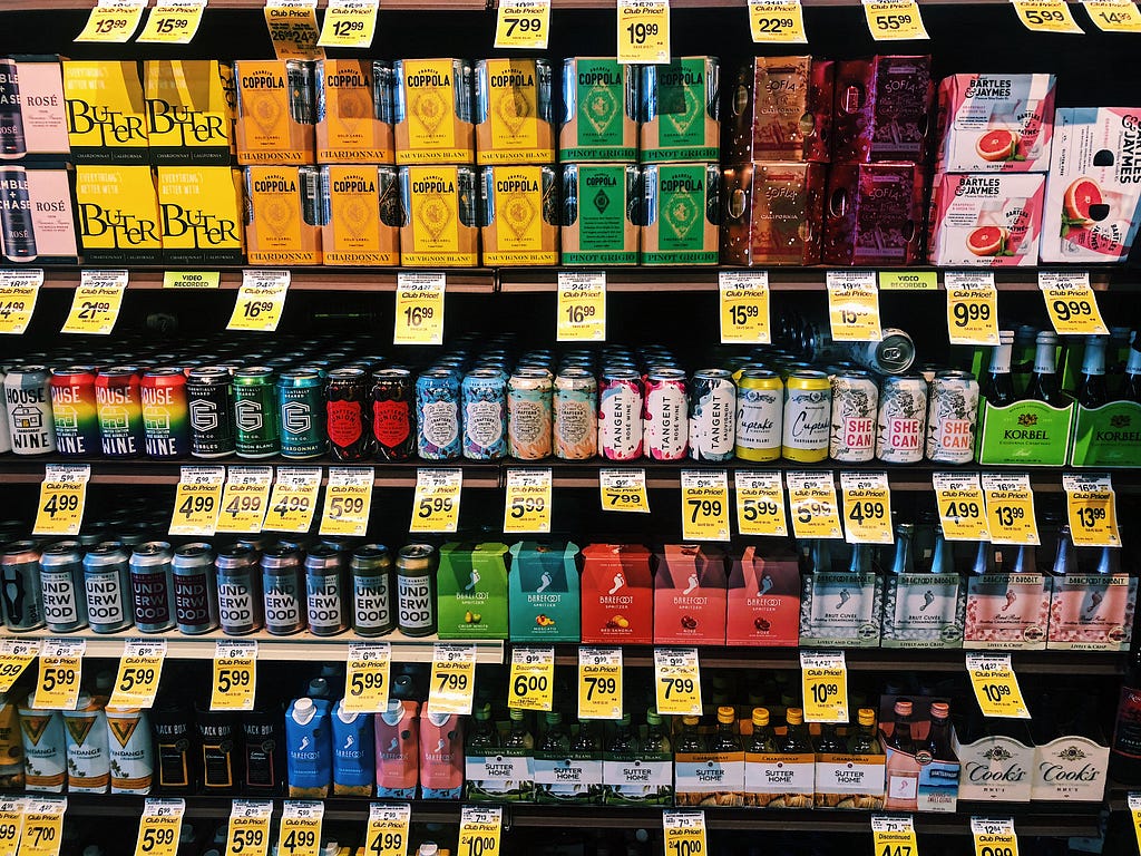 Canned wine lined up in multiple rows at a grocery store.