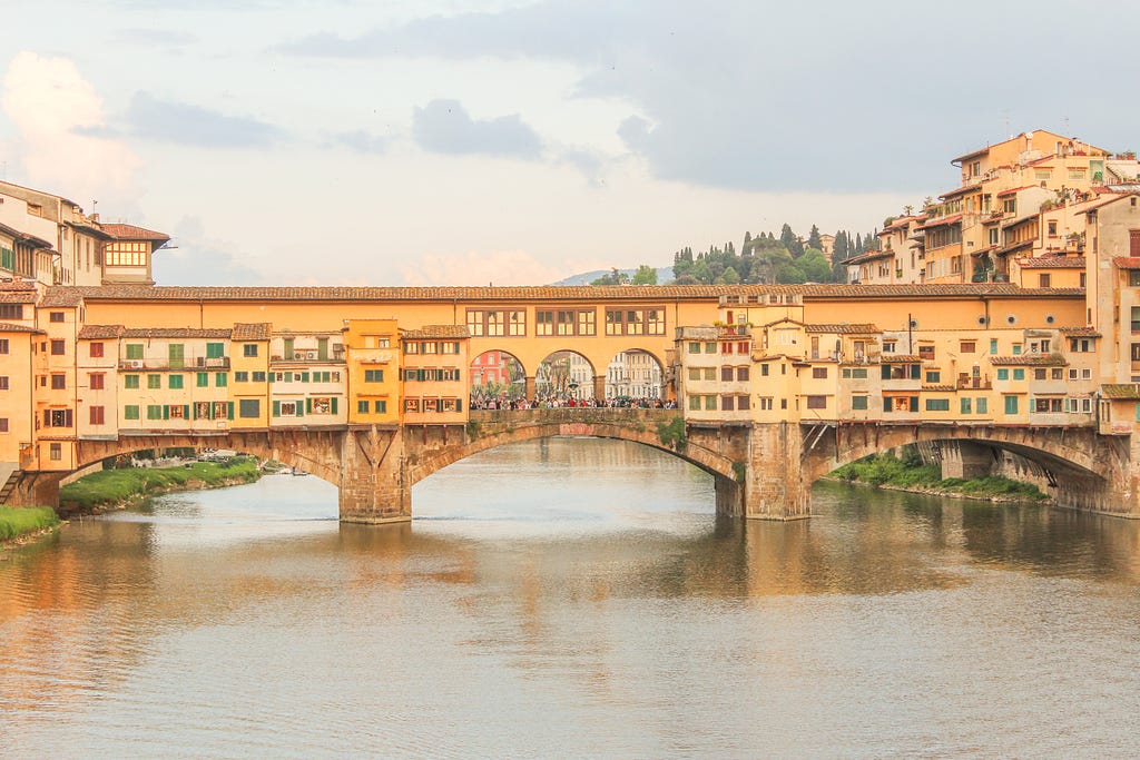 bridge in florence with colourful buildings banked on river