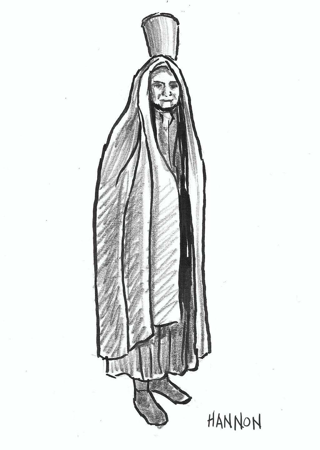 A woman in robes and a hood carries a bucket on her head.