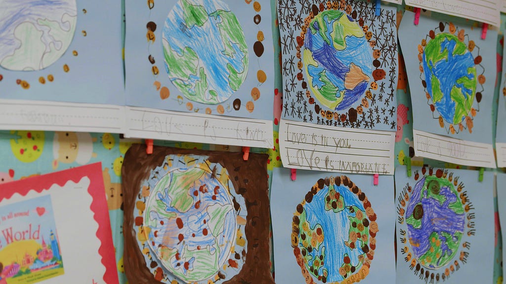 A close-up of student artwork that features drawings of the world.