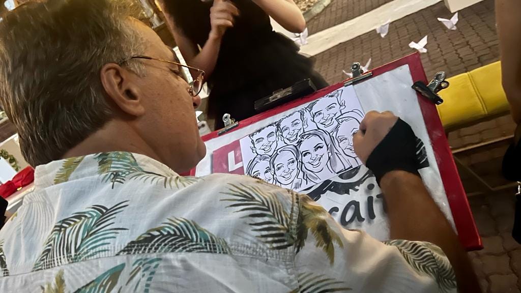 Gary Carvalho sketching a group caricature
