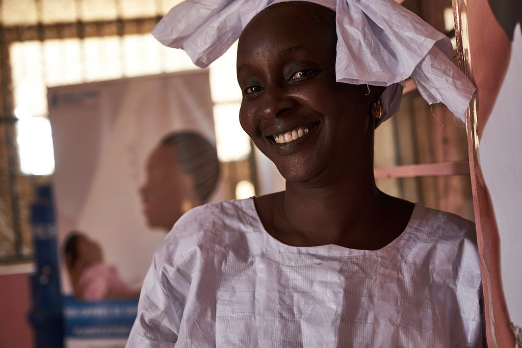 Ndéye Falls visits an MSI clinic wearing a bright white dress.