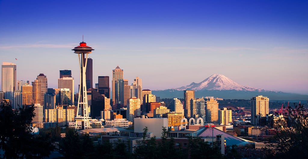 A photo of Seattle, including the space needle, with a clear view of Mt. Rainier in the background.