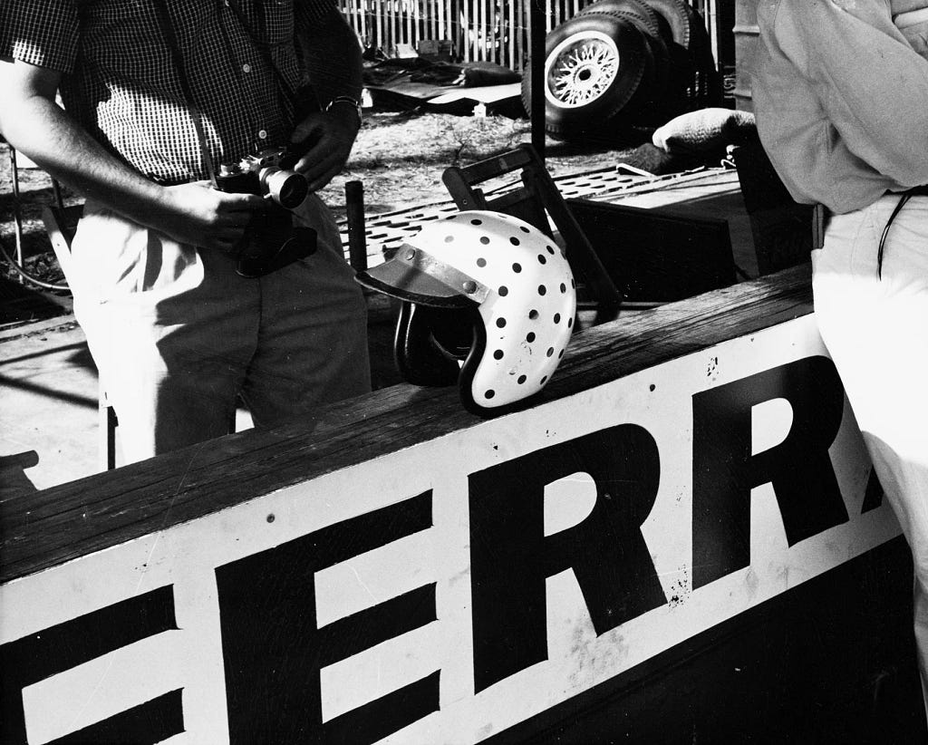 McCluggage’s signature polka-dotted helmet sits atop a wall that reads “FERR” in this black-and-white photo.