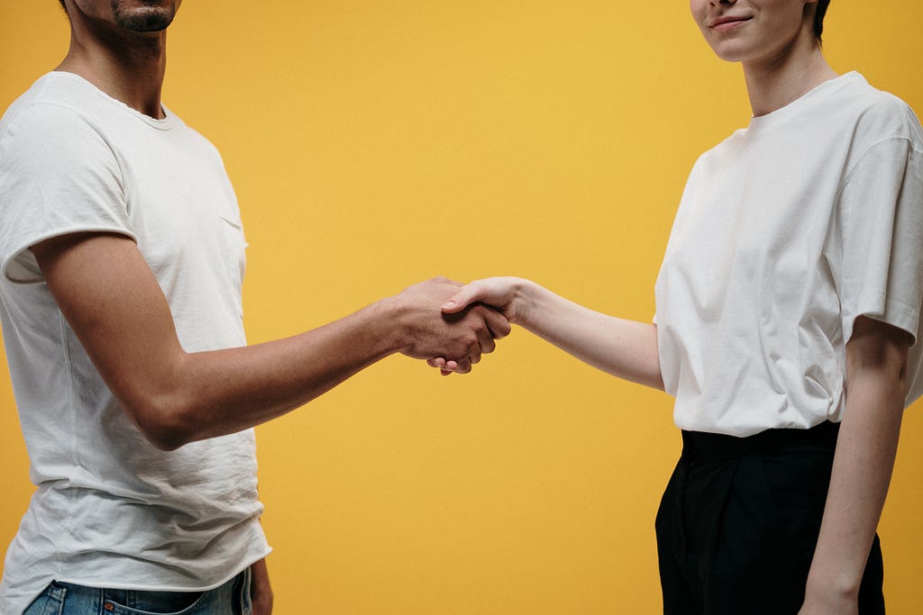 2 people shaking hands.