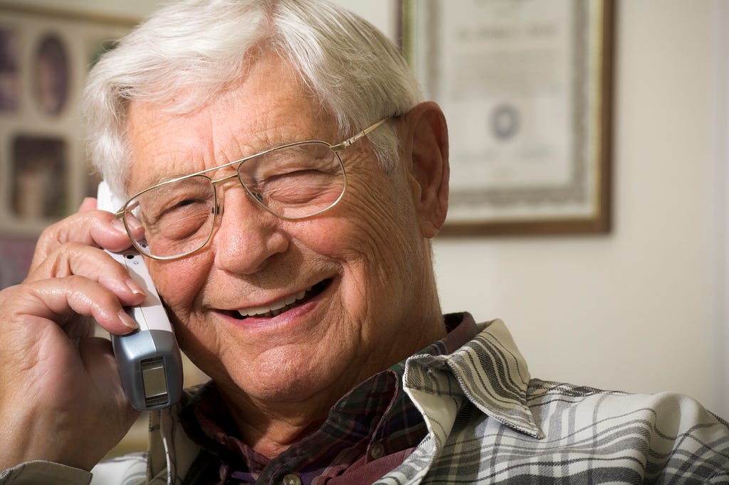 Smiling gentleman on the telephone, photo from Deafblind UK