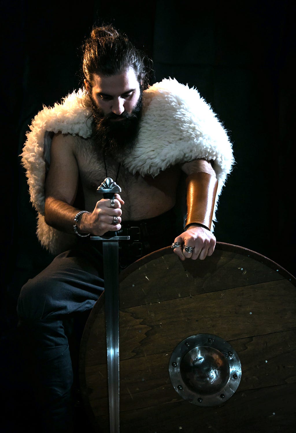 A Portrait of a Medieval Warrior who is sitting with his sword and shield.