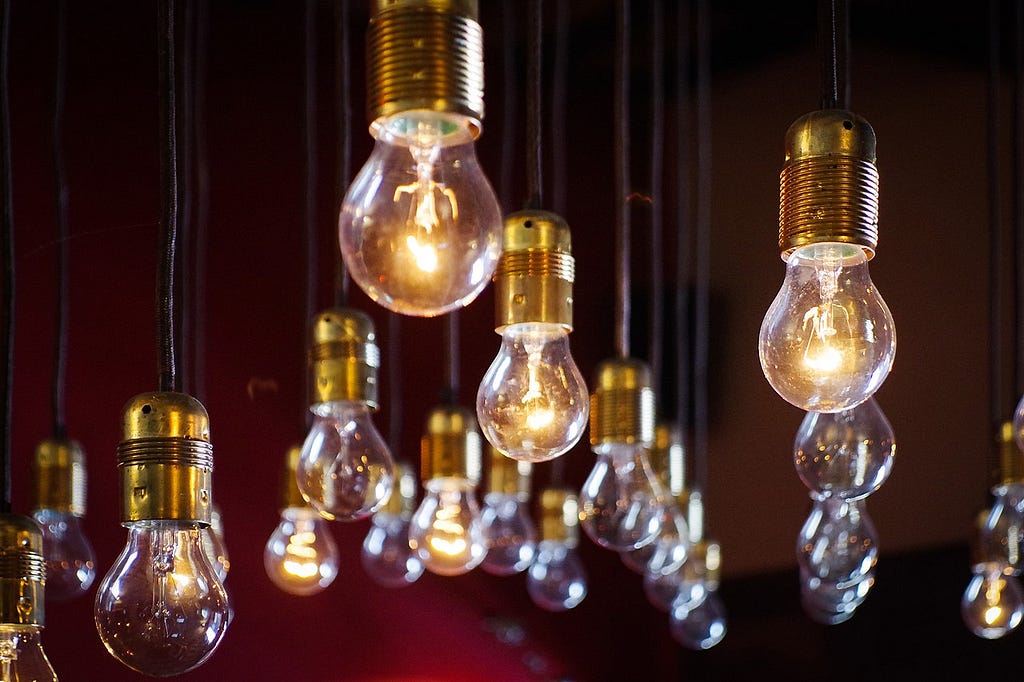 Light bulbs hanging from a ceiling, with some of them lit.