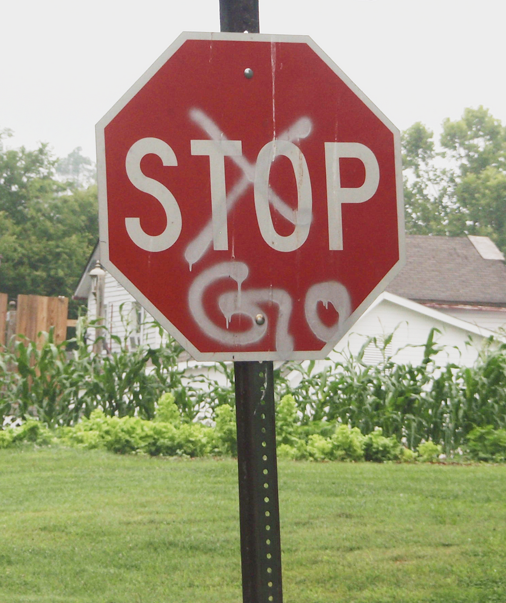 A Stop sign with the word “Stop” crudely crossed out and replaced with spray painted “Go”