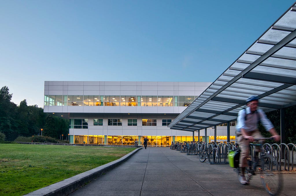 Photo of the Intramural Activities building, with a bicyclist riding on the right side of the photo.