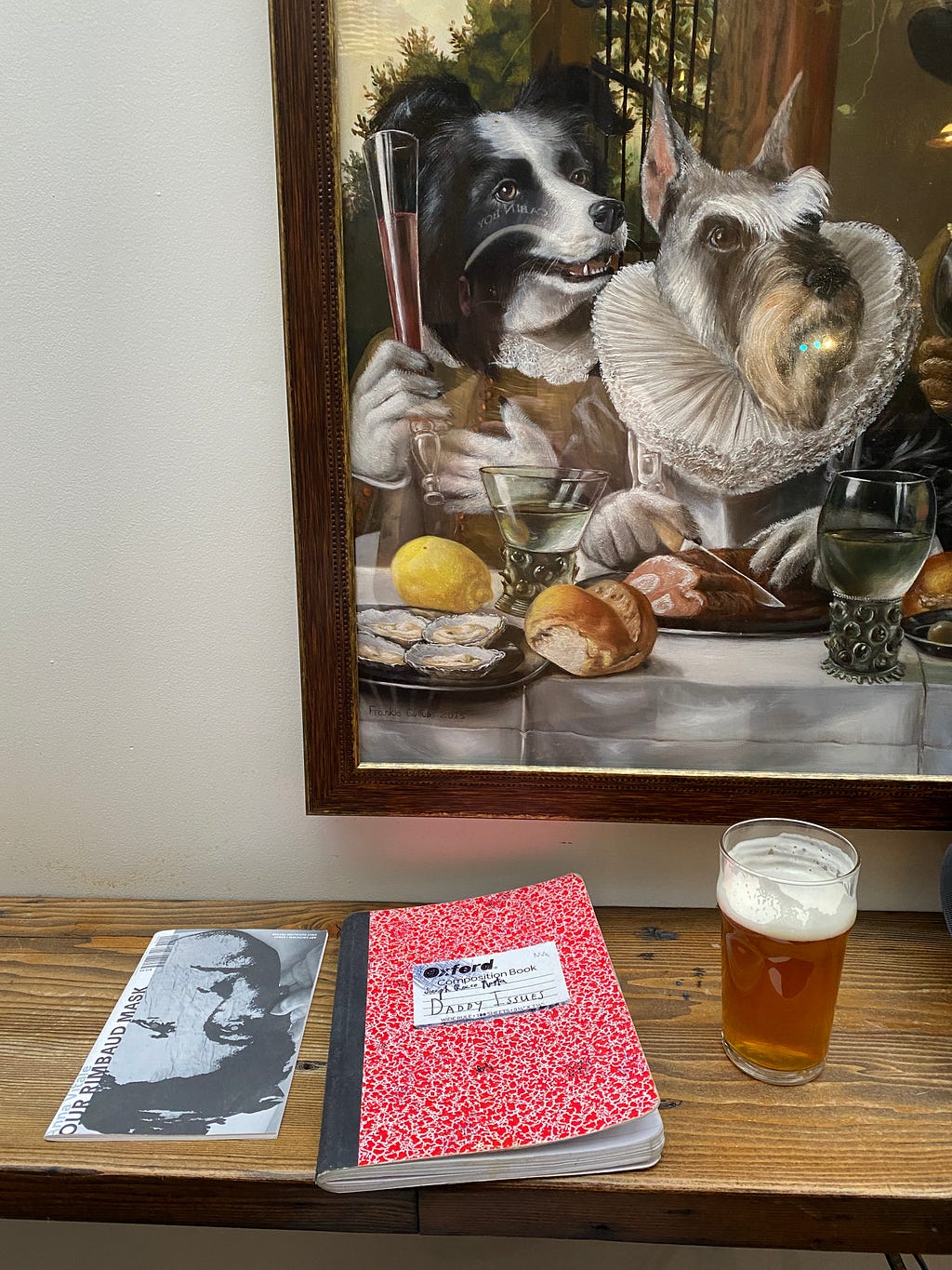 composition notebook, zine, and beer on bar