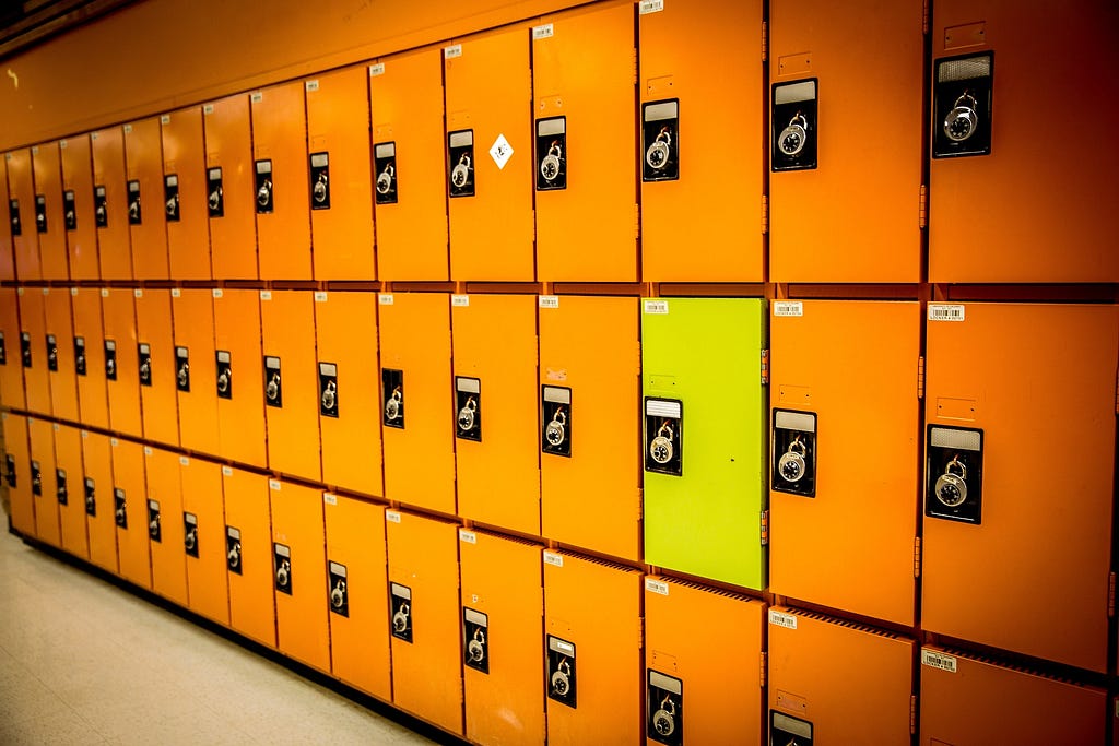 Identical orange lockers with one yellow locker.