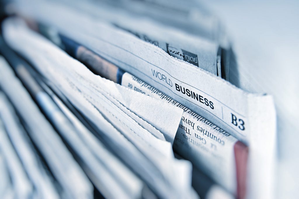 A stack of newspapers with focus on World Business news.