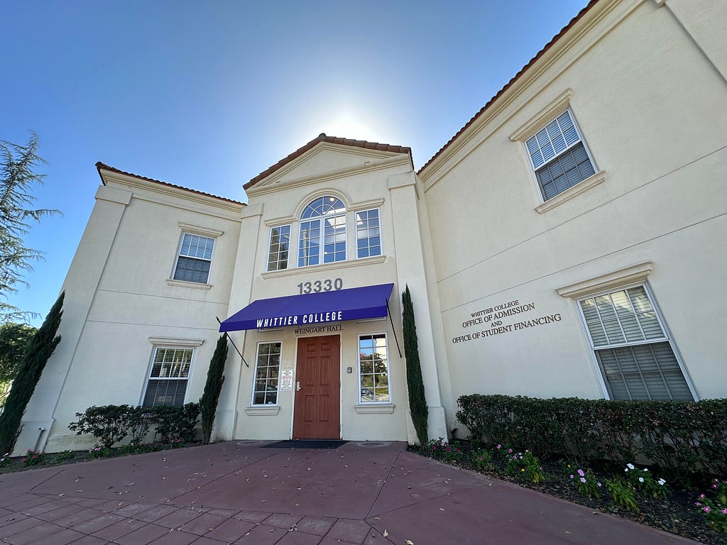 A 0.5 image of the Whittier College Office of Admissions and Financial Aid building against a backdrop of a blue sky.