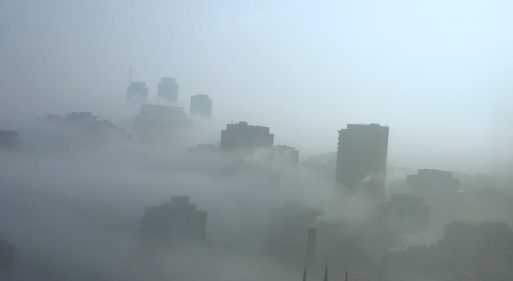 A cityscape covered by thick fog