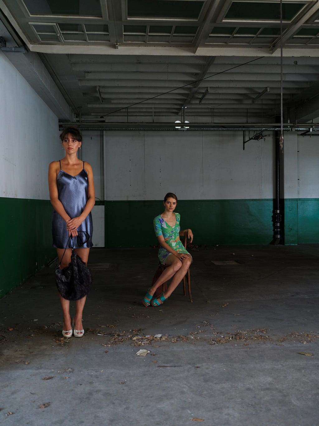 Empty garage, two models in short dress and a loaf of dried leaves