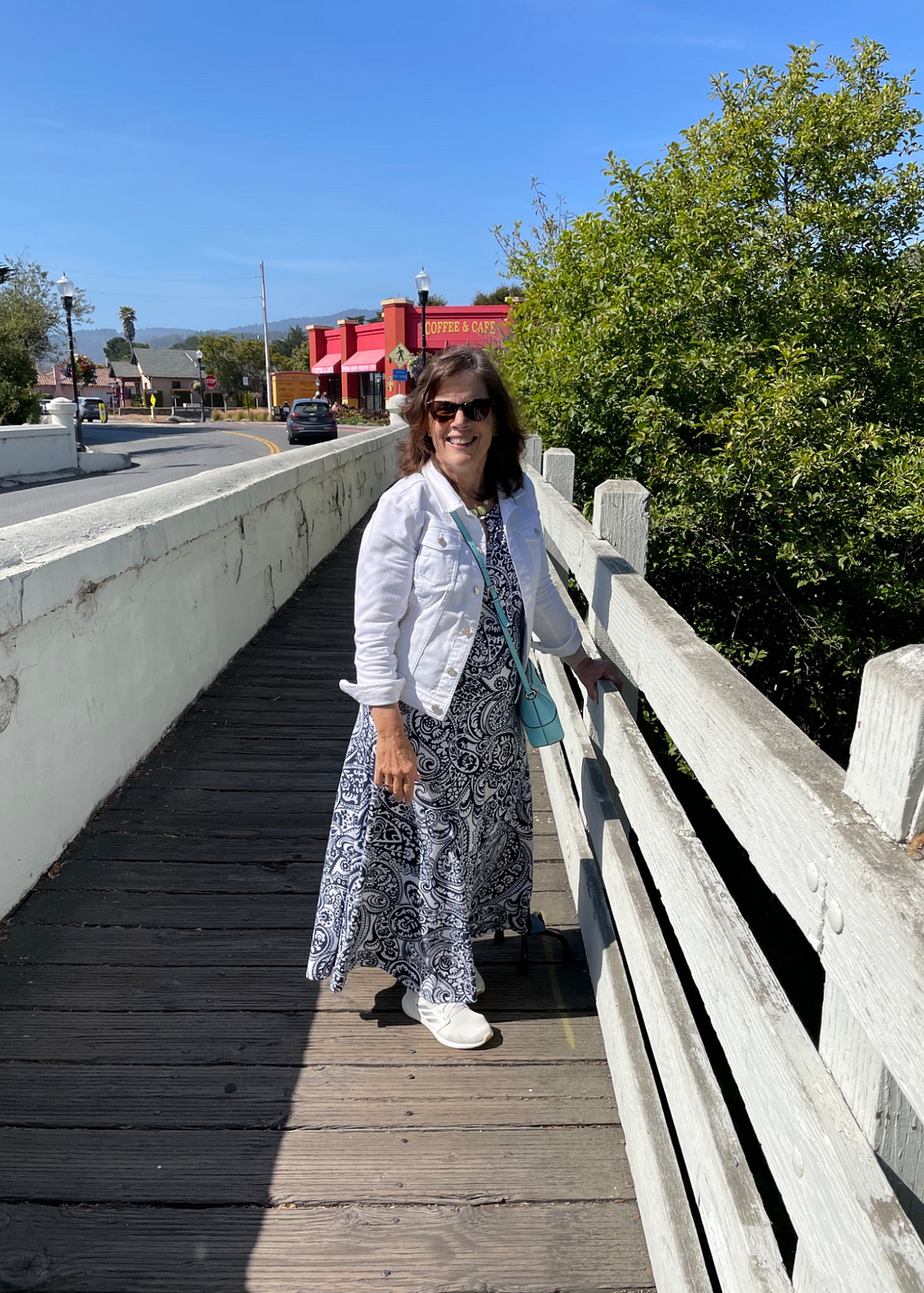 Jan is out for a walk, and stands on bridge on a gorgeous, sunny day in Half Moon Bay, California.