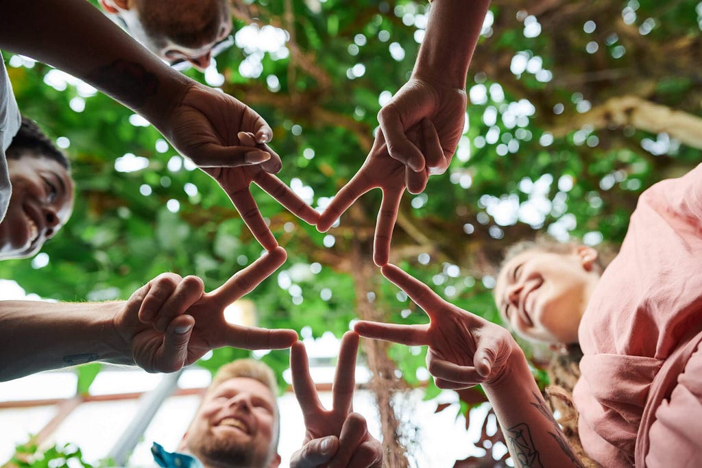 People in circles create a star shape using their fingers.