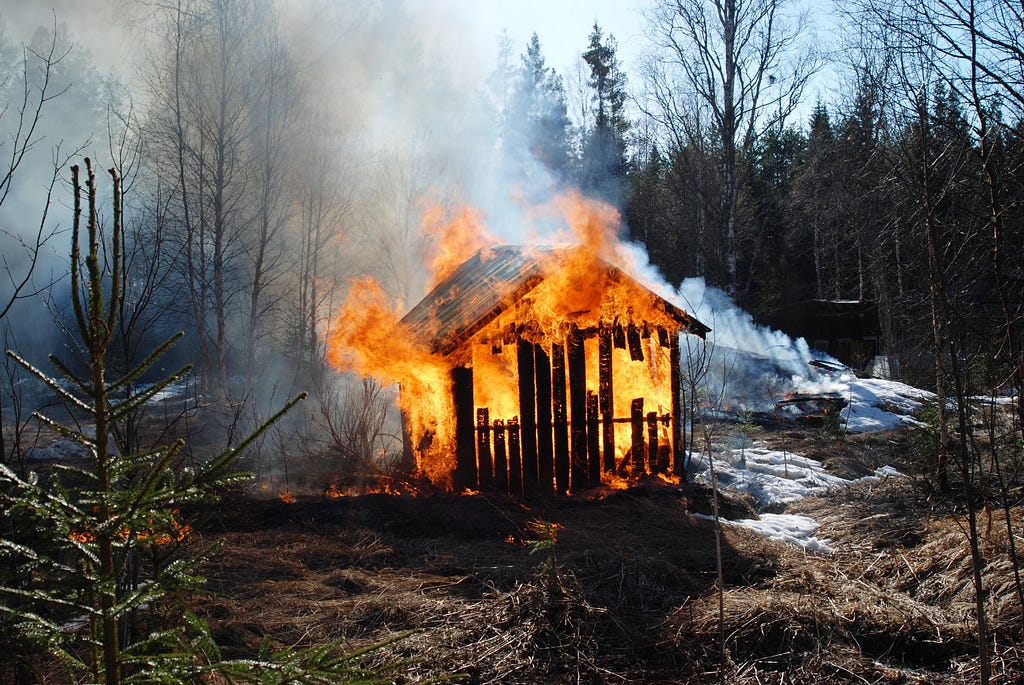Burning hut in the forest.