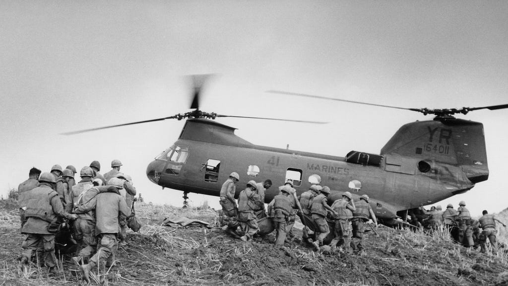 U.S. Marines carry their dead and wounded to a waiting helicopter near the western edge of the demilitarized zone in South Vietnam on June 21, 1968