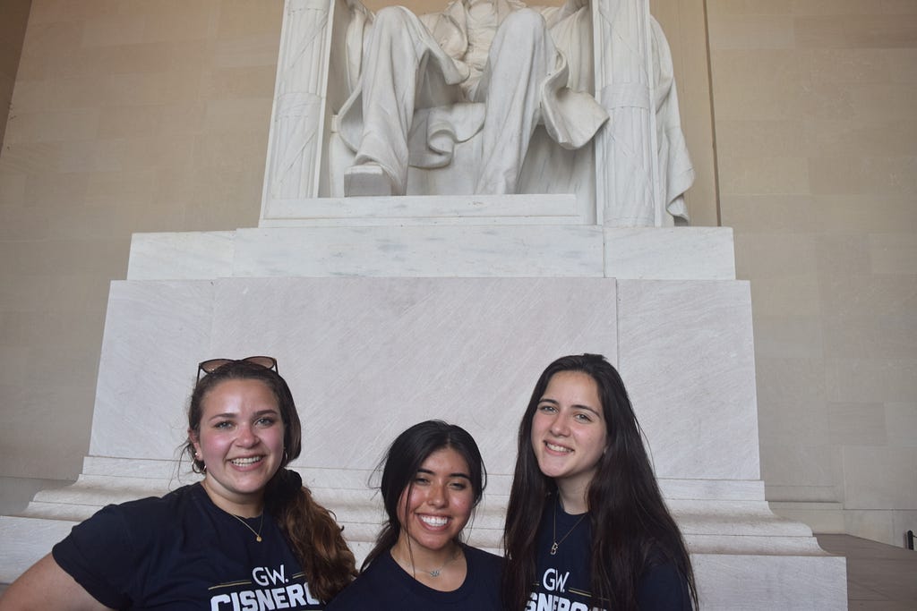 Three students posing in front of Lincoln Memorial