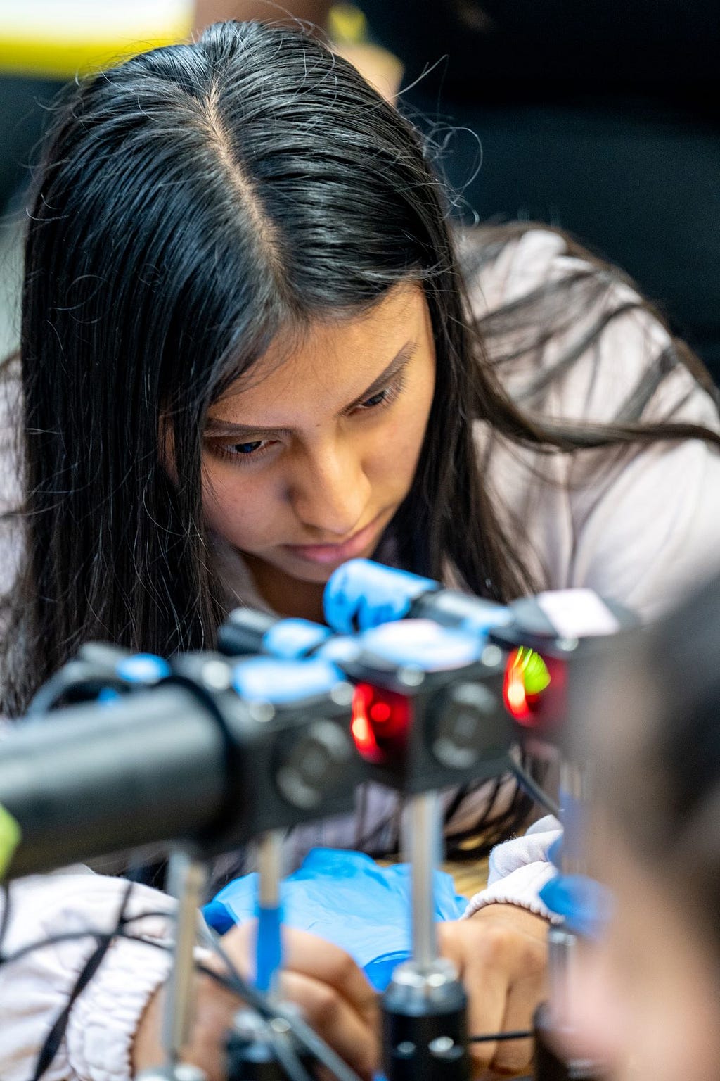 Mount Vernon High School student Gladys Gonzalez focuses as she puts together a piece of a microscope.