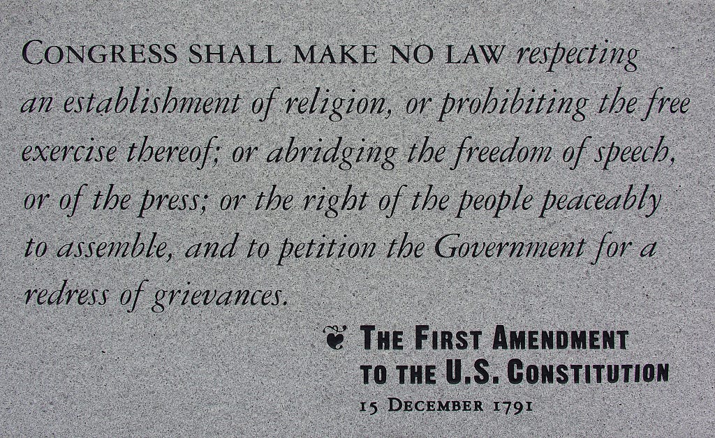 A photograph of a stone plaque engraved with the First Amendment to the United States Constitution