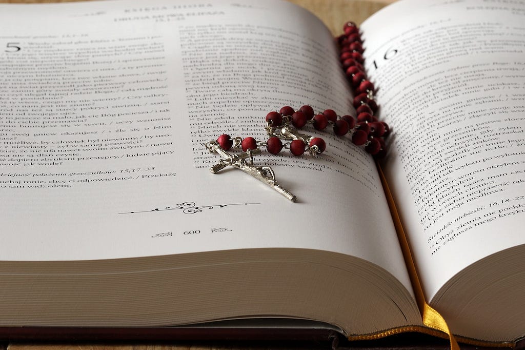 a rosary laying on an open bible