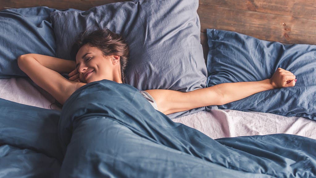 happy, well-rested woman waking up stretching