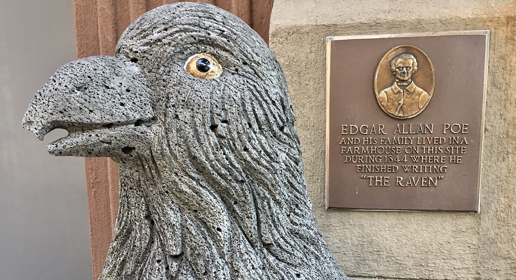 The raven statue with plaque in the background.