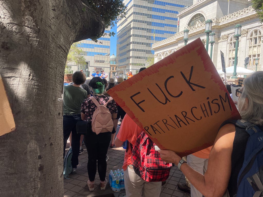 2022年美國加州奧克蘭市政府前的反槍枝暴力集會，「去你的父權主義」（fuck patriarchism）標語。 A sign of “fuck patriarchism” at a gun violence protest in front of Oakland City Hall.