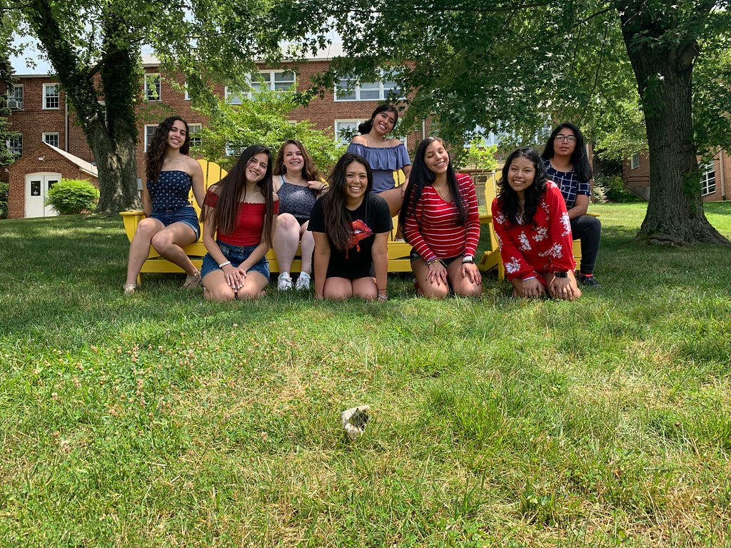 Eight students posing on grass